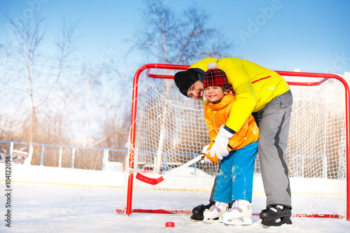 Photography Dad teach little boy son to play ice hockey