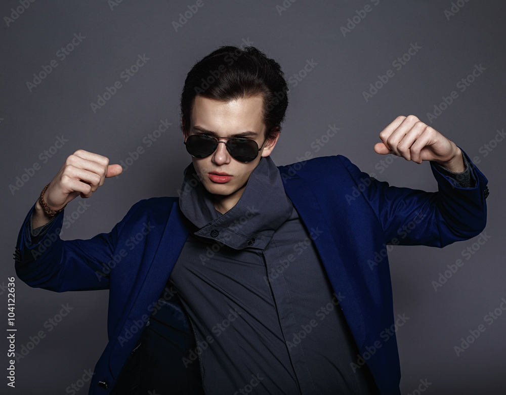 Vogue handsome man in the jacket and sunglasses in the studio Vogue handsome man in the jacket and sunglasses in the studio