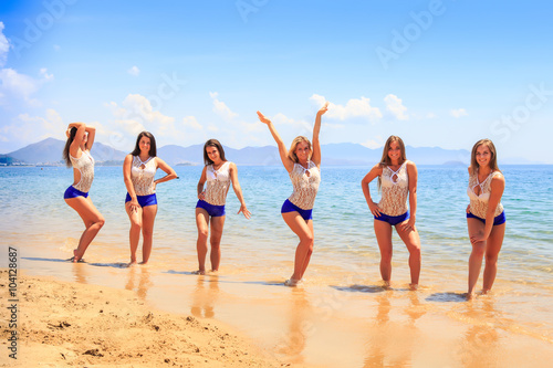 closeup cheerleaders pose in water hands up on hips