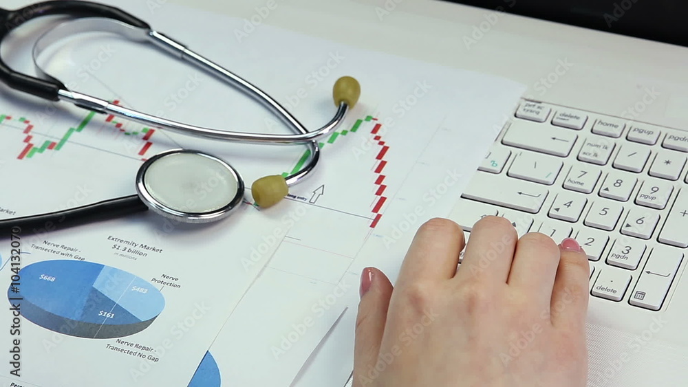 Medical scientist conducting research, comparing diagrams, working on laptop Medical scientist conducting research, comparing diagrams, working on laptop