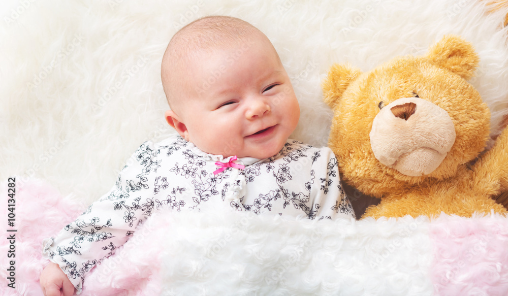 Newborn baby girl on her blanket with her teddy bear Newborn baby girl on her blanket with her teddy bear