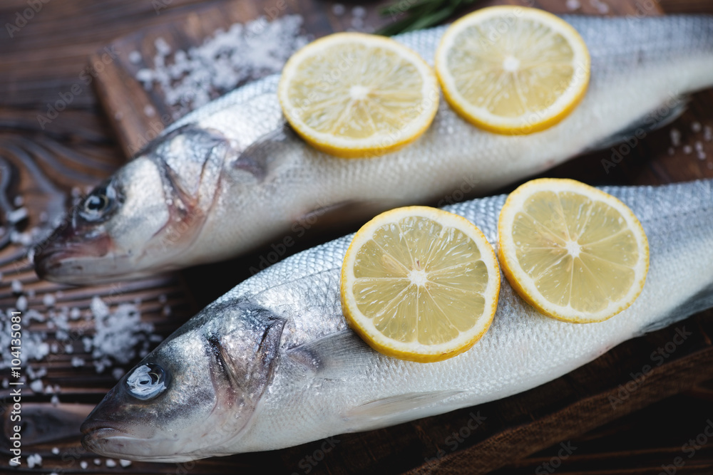 Close-up of raw fresh seabass fish with lemon and sea salt Close-up of raw fresh seabass fish with lemon and sea salt