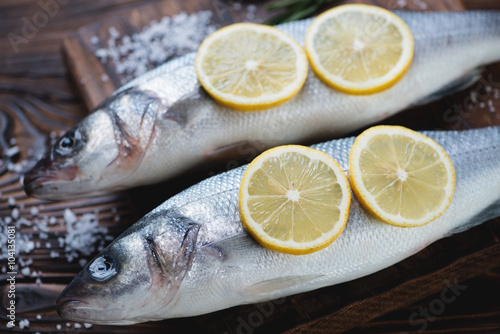 Close-up of raw fresh seabass fish with lemon and sea salt