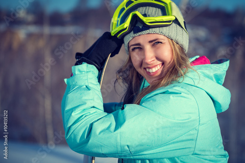 Portrait of beautiful cheerful woman with a snowboard