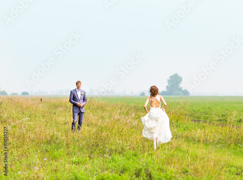 Beautiful bride running in the field