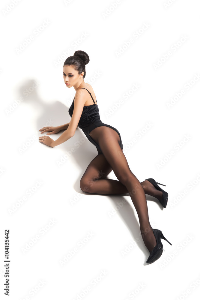 Sexy and seductive woman posing in alluring hosiery over isolated background.