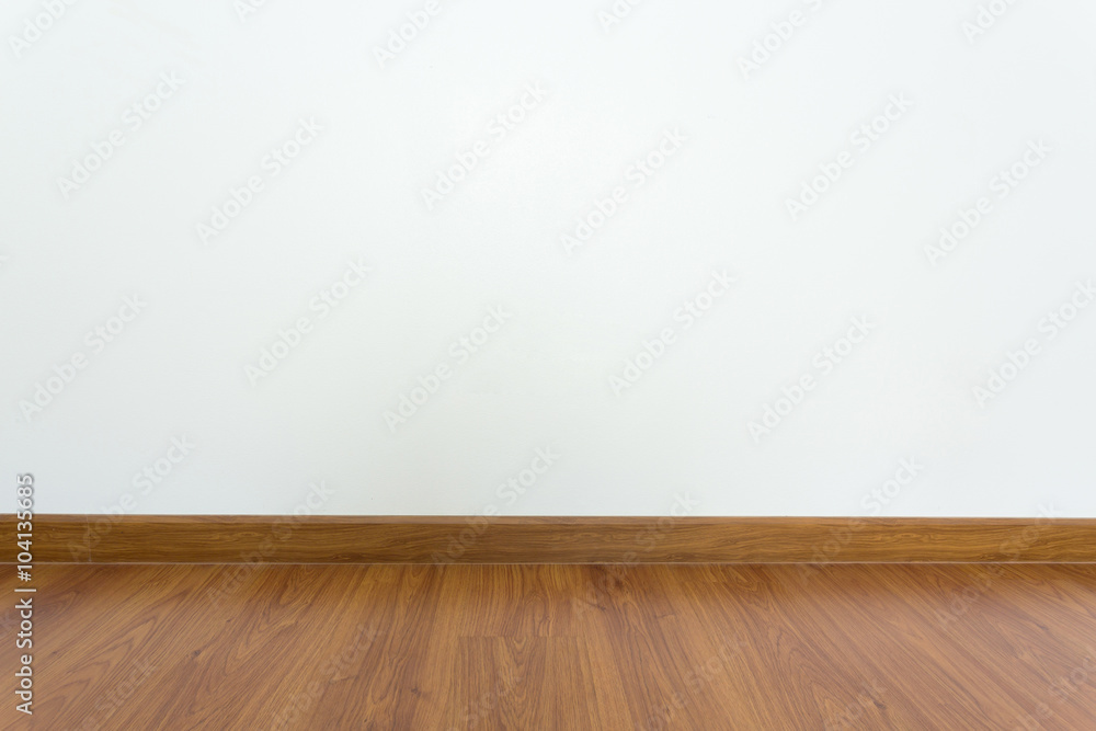 empty room with brown wood laminate floor and white mortar wall empty room with brown wood laminate floor and white mortar wall