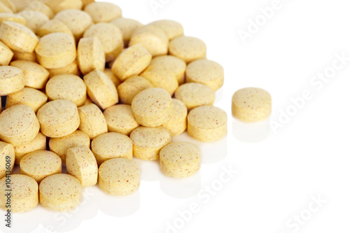 Folic Acid Vitamin Supplements. A pile of folic acid vitamin supplement tablets isolated on a white background.