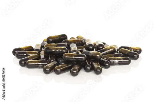 Olive Leaf Vitamin Supplements. A pile of olive leaf supplement capsules isolated on a white background.