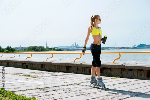 Young, beautiful, sporty and fit girl rollerblading on inline skates