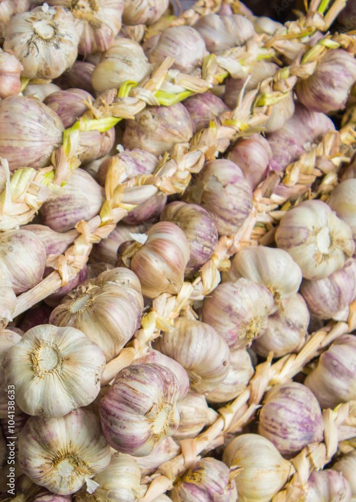 Heap of fresh whole garlic on stall as background