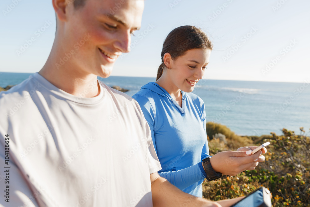 Young couple with smartphones outdoors