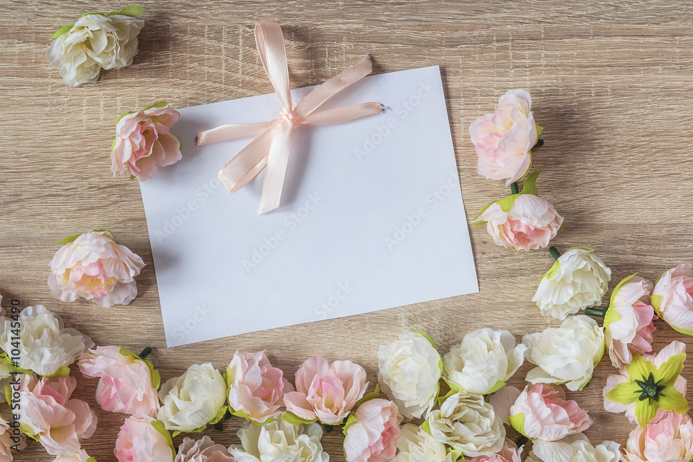 White blank card with a ribbon on a a wooden background with pre White blank card with a ribbon on a a wooden background with pre