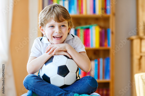 Kid boy watching soccer or football game on tv © Irina Schmidt