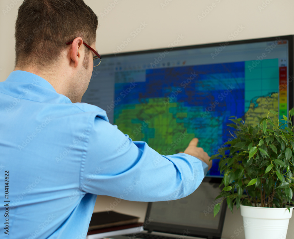 Fototapeta premium Handsome male meteorologist working with touchscreen.