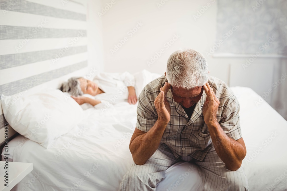 Frustrated senior man sitting on bed Frustrated senior man sitting on bed