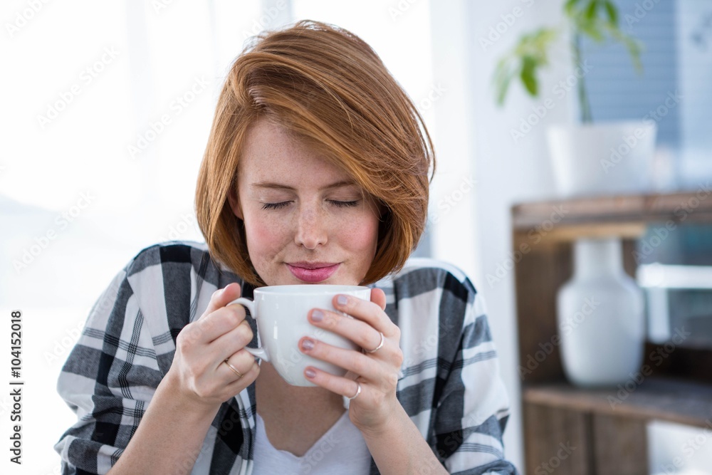smiling hipster woman smelling a cup of coffee