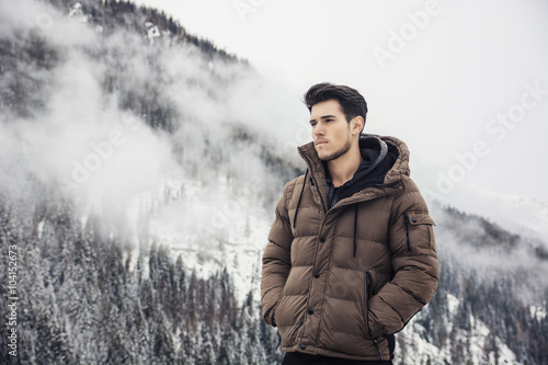 Man in outerwear sitting while looking at camera