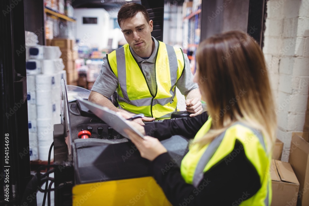 Warehouse worker talking with forklift driver Warehouse worker talking with forklift driver