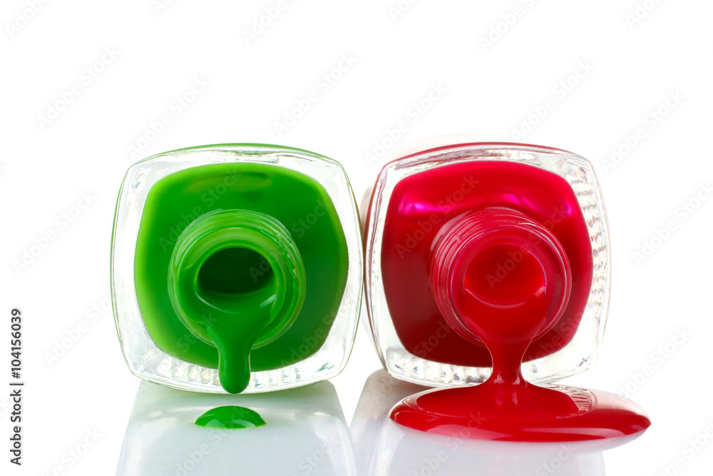 red and green nail Polish in bottles and a little bit spilled on a white isolated background red and green nail Polish in bottles and a little bit spilled on a white isolated background