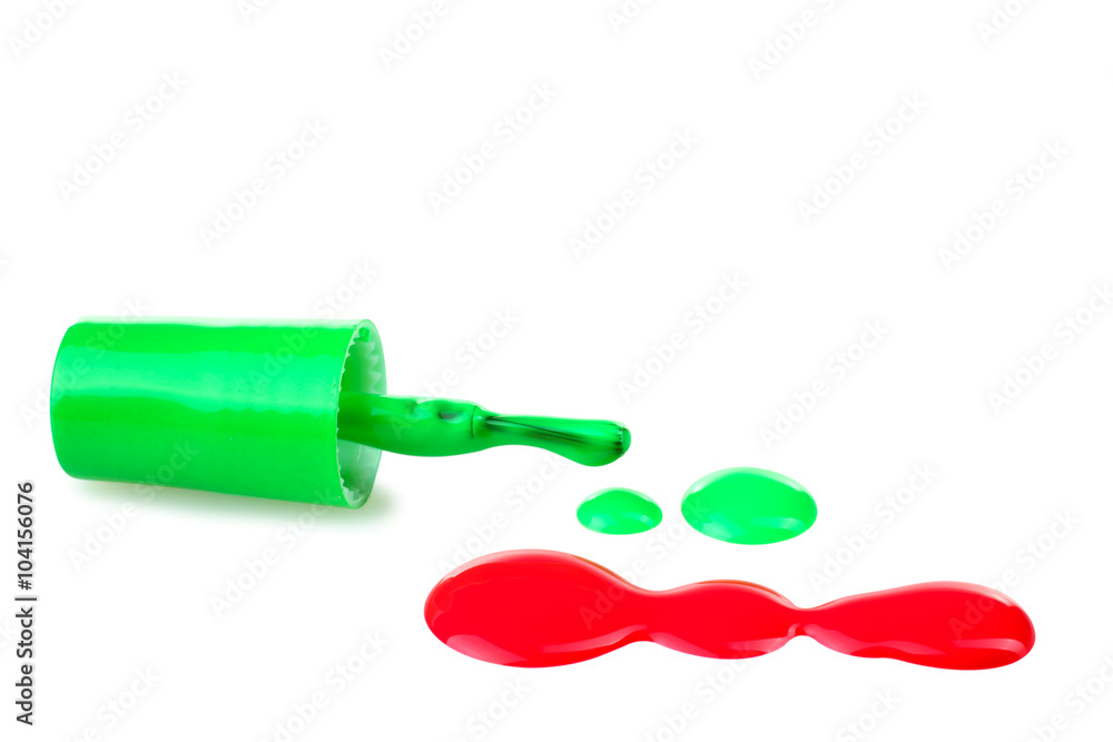 green and red nail Polish near brush a little bit spilled on a white isolated background green and red nail Polish near brush a little bit spilled on a white isolated background
