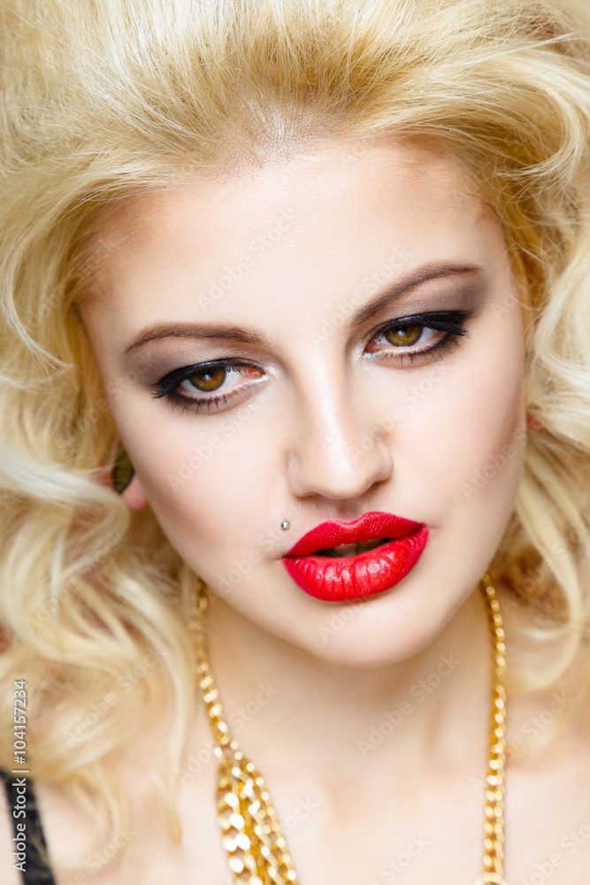 Portrait of beautiful blonde glam rocker woman on orange background. Closeup of Beauty Woman face make up. Bright make-up with sexy red lips and perfect skin Portrait of beautiful blonde glam rocker woman on orange background. Closeup of Beauty Woman face make up. Bright make-up with sexy red lips and perfect skin