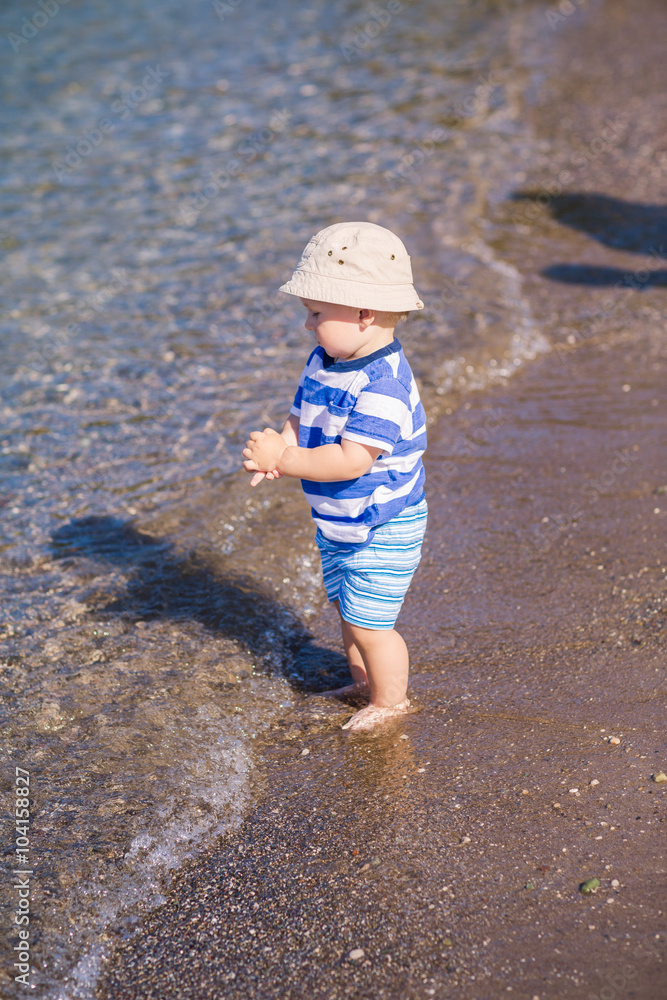 Cute little baby boy exploring the beach