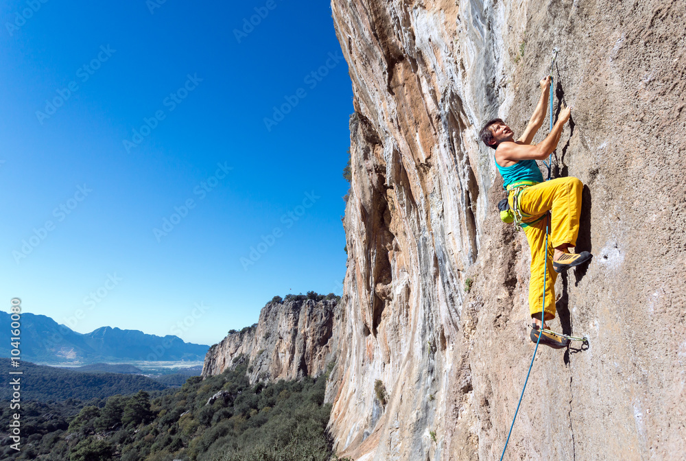 Mature male extreme Climber moving up on rocky Wall