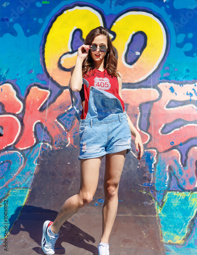 Hipster girl in the jeans and sunglasses outdoor