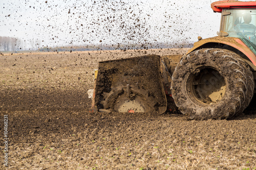 Tractor with double wheeled ditcher digging drainage canal photo