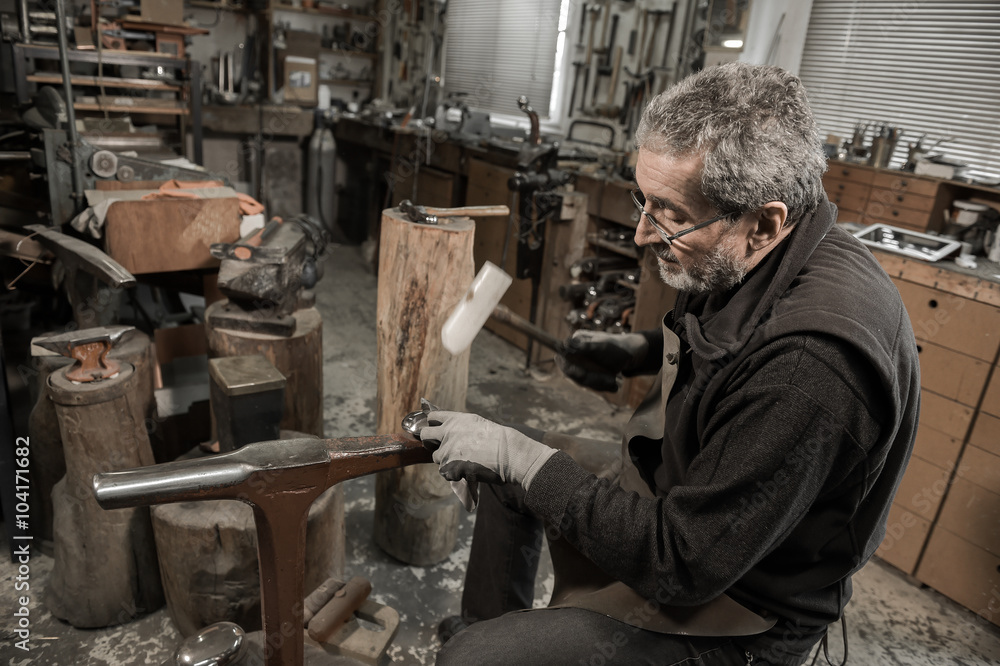 Master goldsmith working with silver-Shaping of the object by ha