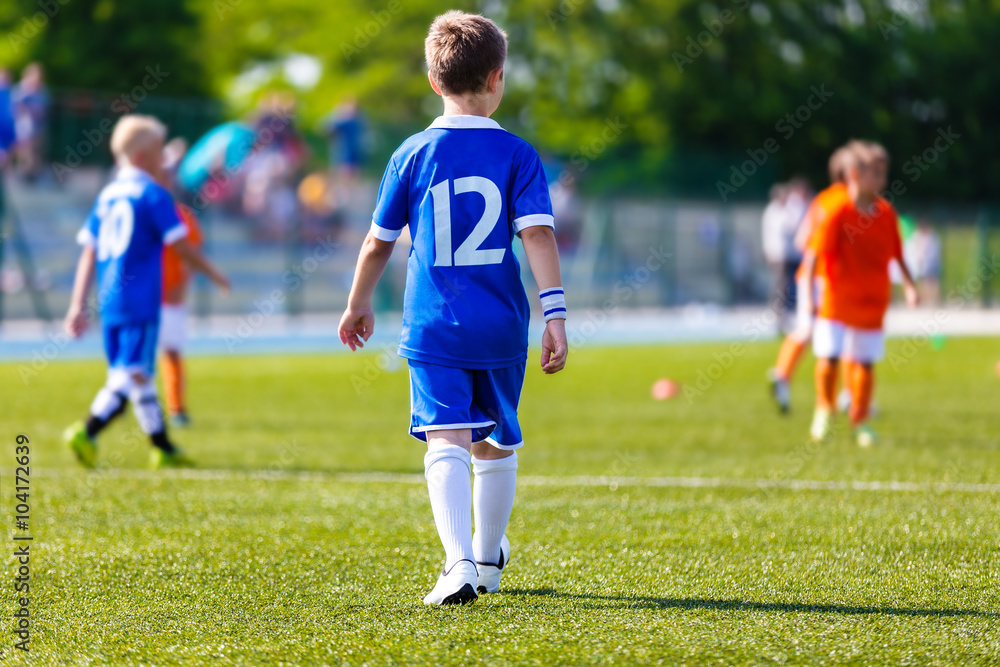 Young boy as a soccer football player at a sports stadium. Youth soccer football match at school tournament.