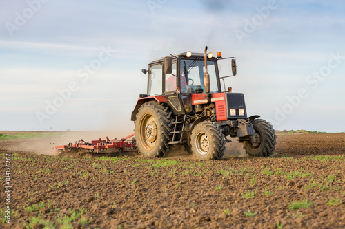 Farmer cultivating arable land before seeding