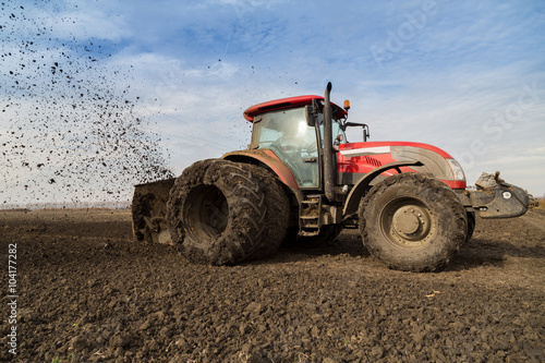 Tractor with double wheeled ditcher digging drainage canal