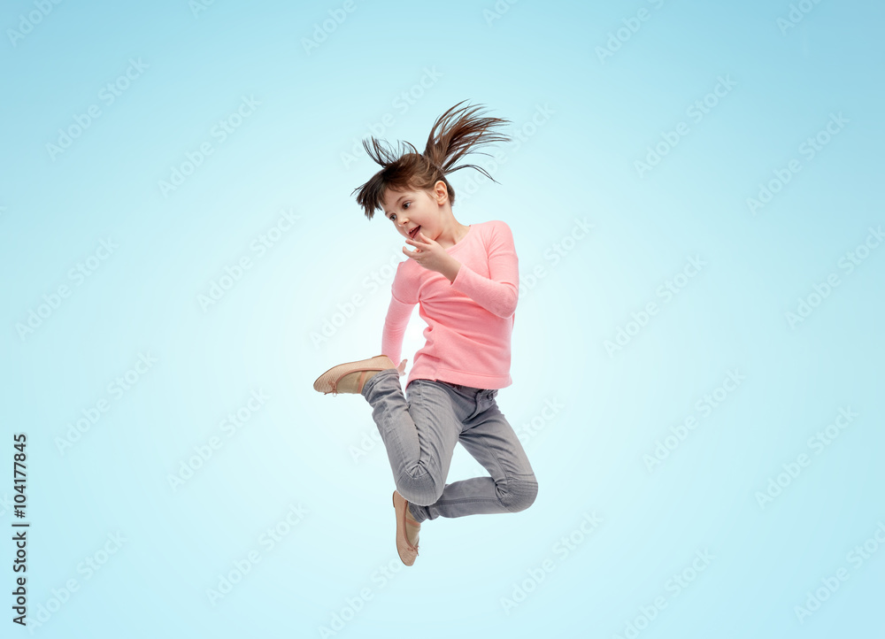 happy little girl jumping in air over blue happy little girl jumping in air over blue