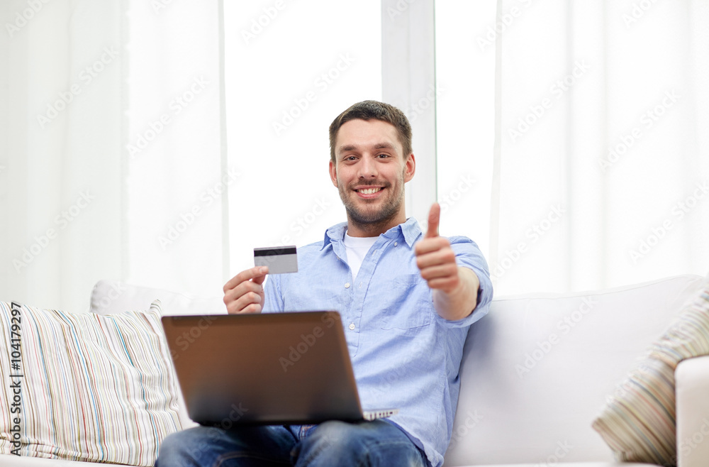 man with laptop and credit card showing thumbs up man with laptop and credit card showing thumbs up
