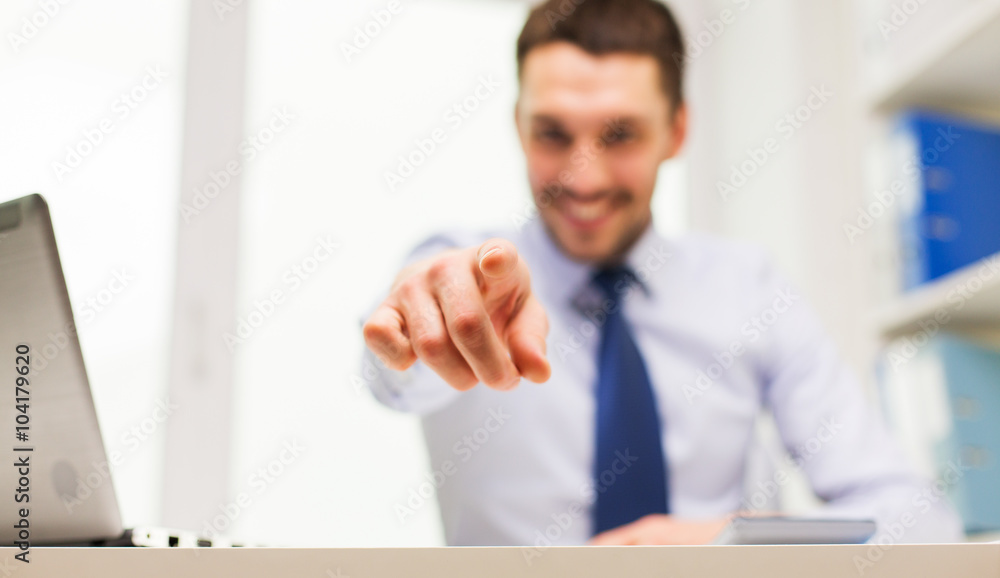 smiling businessman pointing on you in office