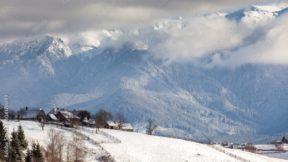 Wintry rural mountain scenery in the valleys of Bucegi mountains in Magura village, Brasov county, Romania. Touristic destinations for winter vacation.