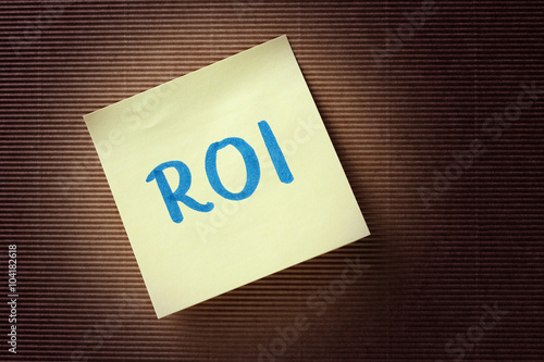 ROI (Return On Investment) acronym on yellow sticky note