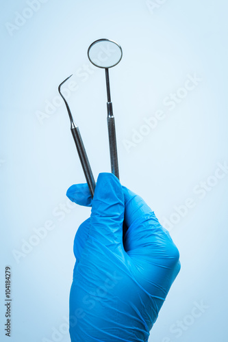 Gloved hand holding dental equipment