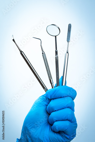 Gloved hand holding dental equipment