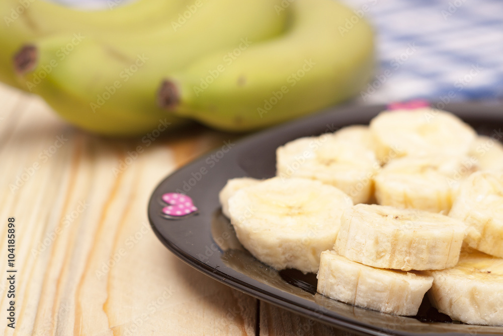 green banana with slices on wooden background green banana with slices on wooden background