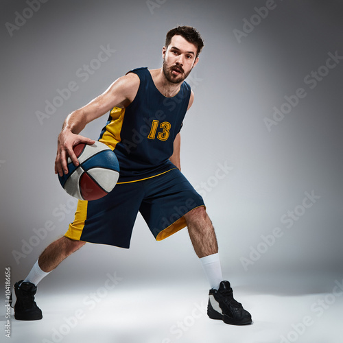Fototapeta Naklejka Na Ścianę i Meble -  Full length portrait of a basketball player with ball 