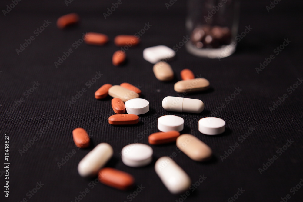 Bunte Tabletten und Kapseln auf schwarzem Hintergrund Bunte Tabletten und Kapseln auf schwarzem Hintergrund