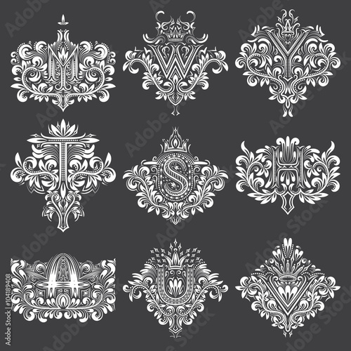 Set of ornamental monogram in coats of arms form. White floral decorations on black. Isolated tattoos in vintage baroque style.