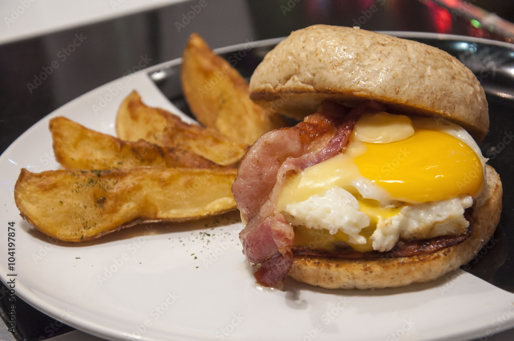 Hamburger with fried eggs , bacon and potato fried