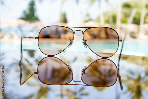 Sunglasses with coconut tree reflection at sea beach
