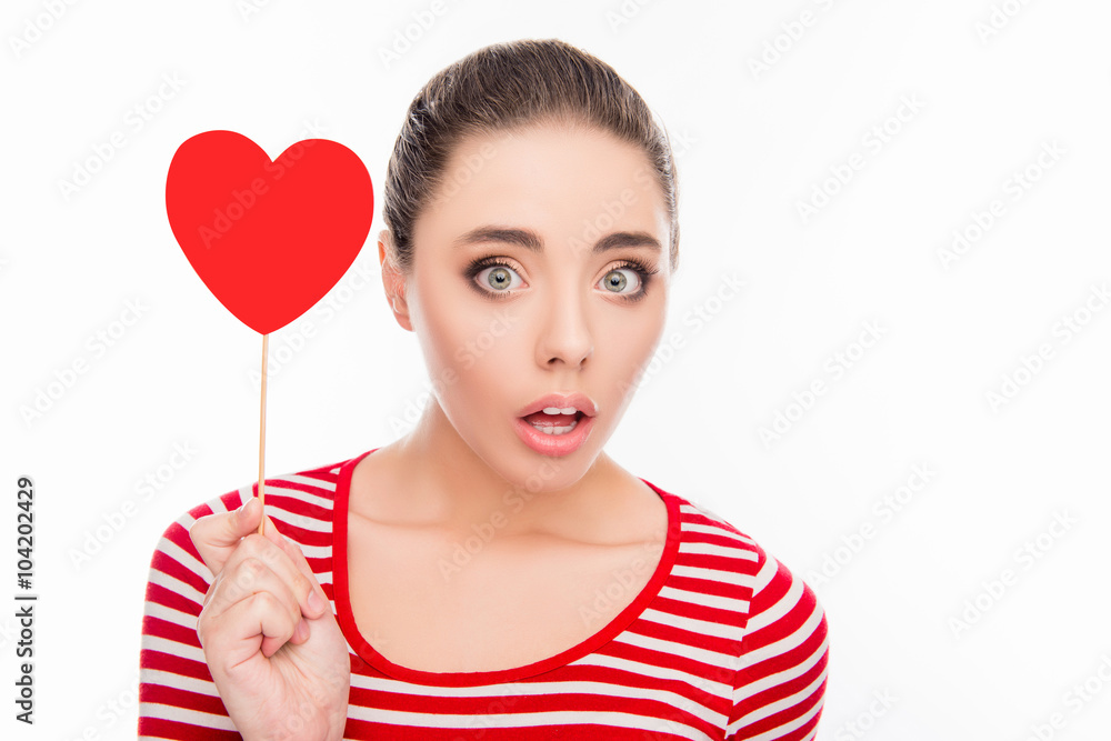 Surprised pretty girl holding red paper heart on stick Surprised pretty girl holding red paper heart on stick