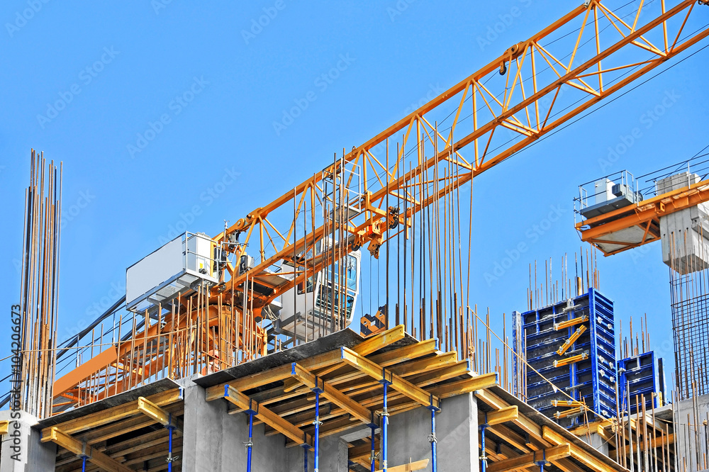 Crane and building construction site against blue sky Crane and building construction site against blue sky
