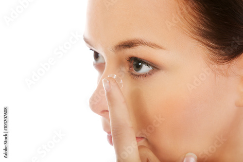 Canvastavla Beautiful young woman putting a contact lens